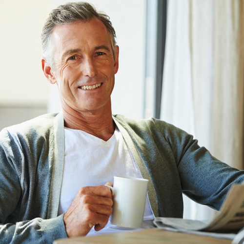 Gentleman reading newspaper while drinking coffee Gentleman reading newspaper while drinking coffee