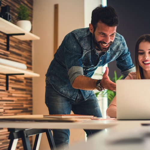 Young man and woman looking at computer together Young man and woman looking at computer together